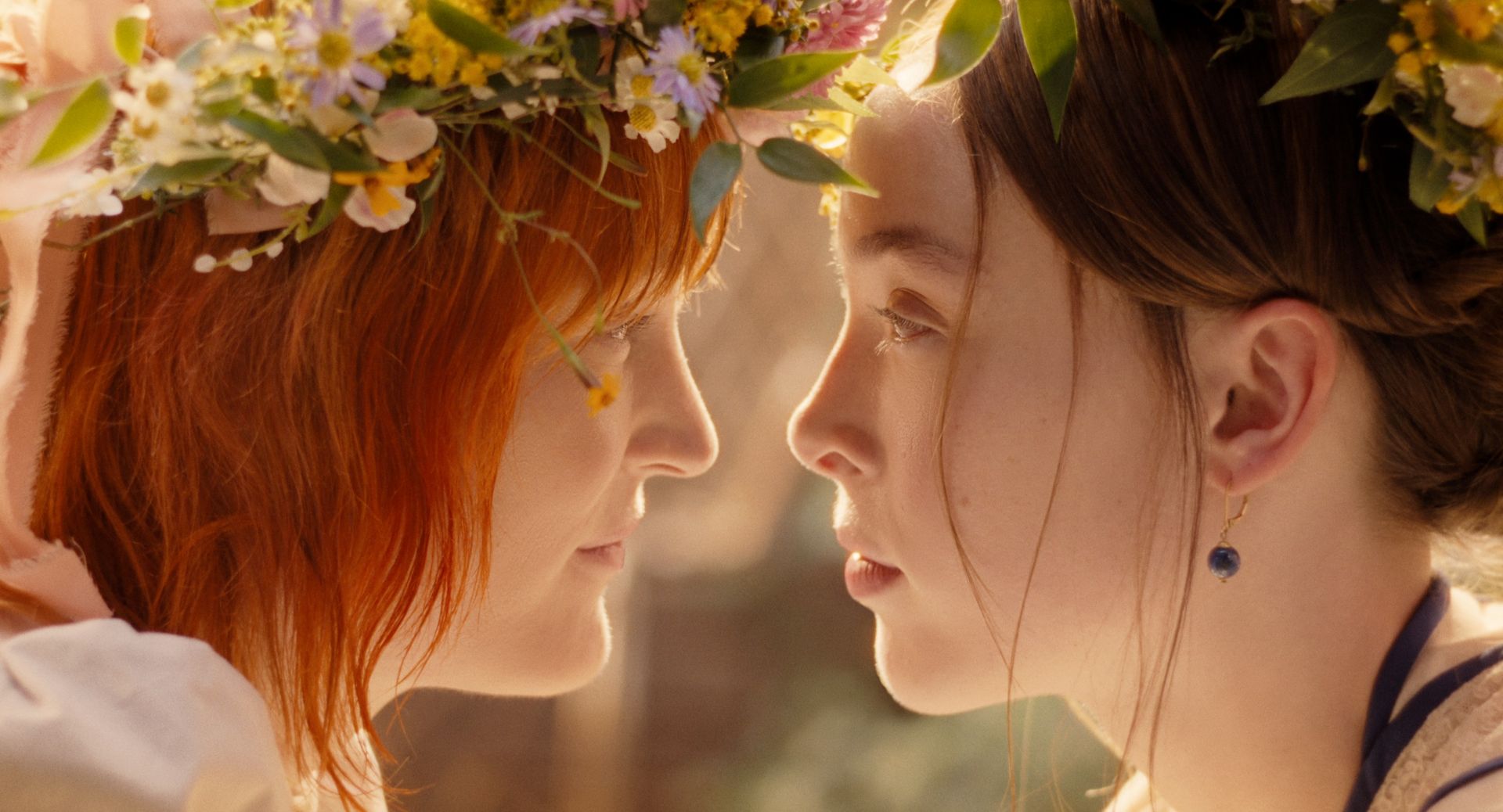 vicky krieps as bridget sullivan wearing a flower crown and leaning in closely to stare into ella beatty as lizzie borden's eyes in a still from monster the lizzie borden story