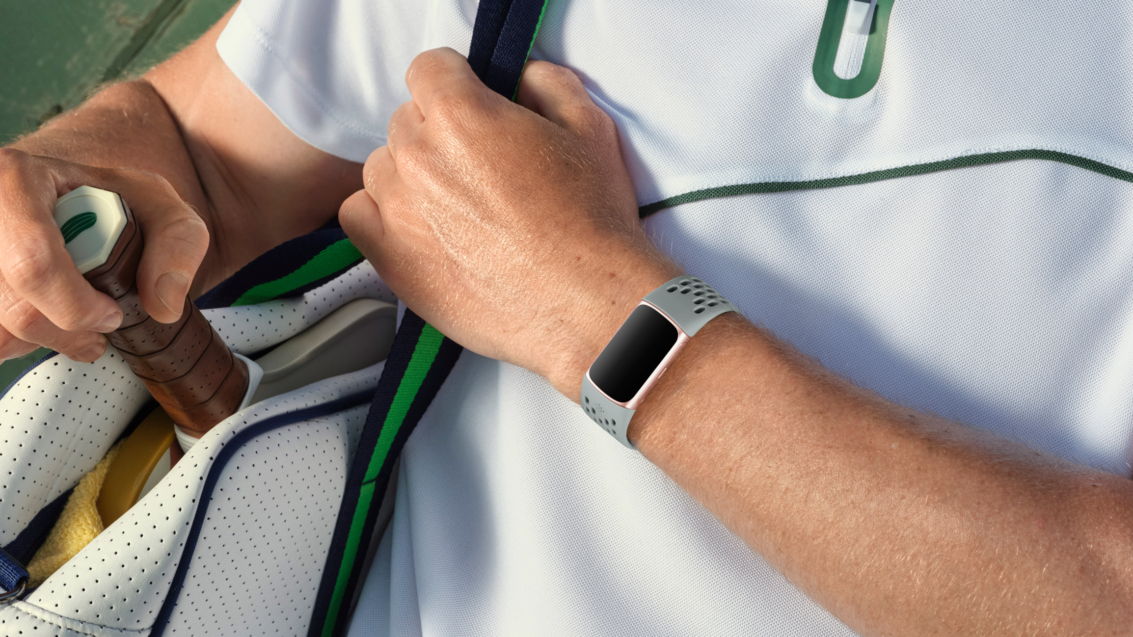 En lysegrå Fitbit Charge 6 rundt et håndledd.