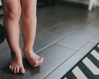 toddler feet on tiles underfloor heating - GettyImages-1175488179