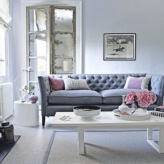 white living room with grey sofa and carpet floor
