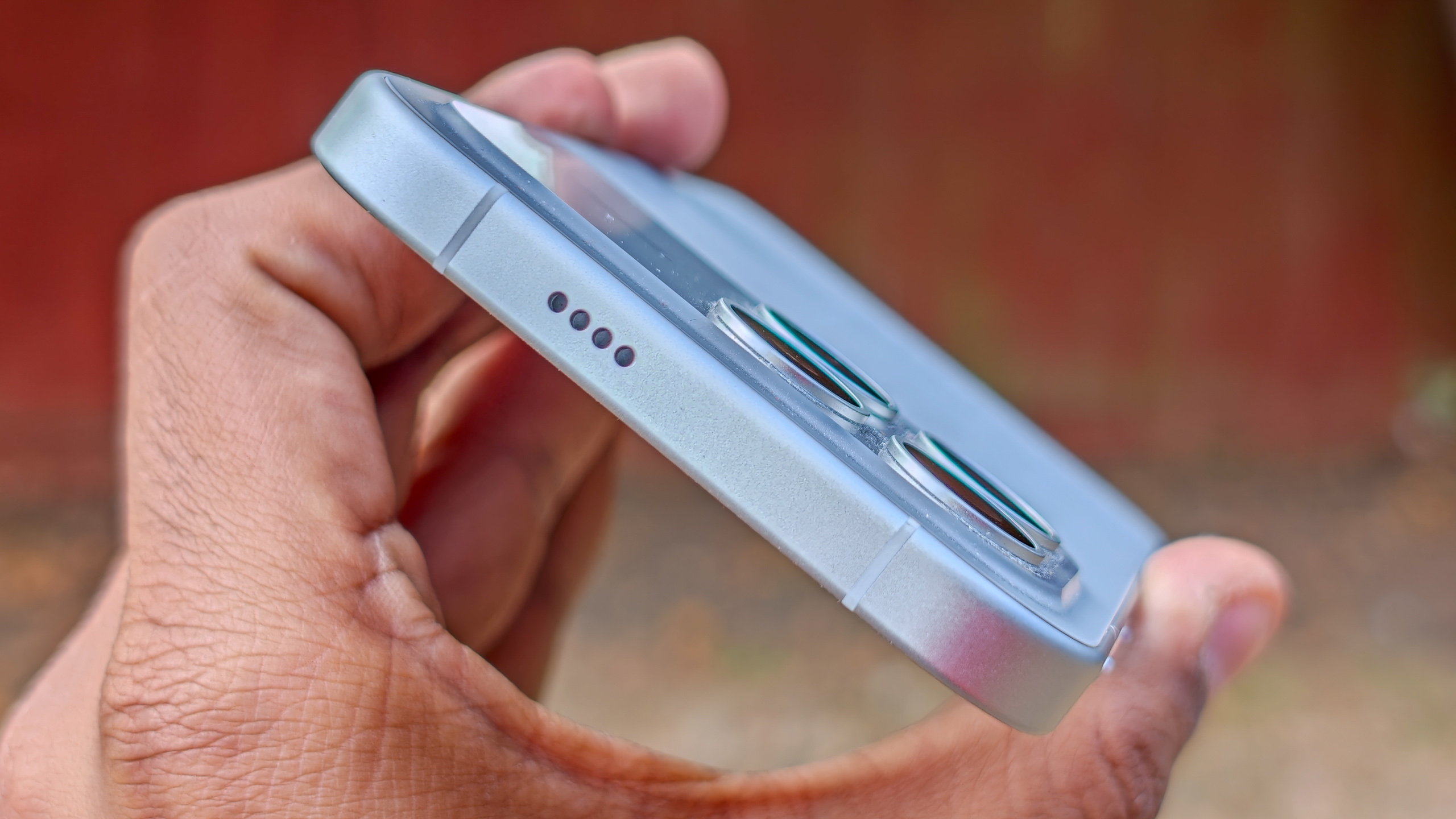 The Poco F8 Pro in Silver in the hand against a garden backdrop