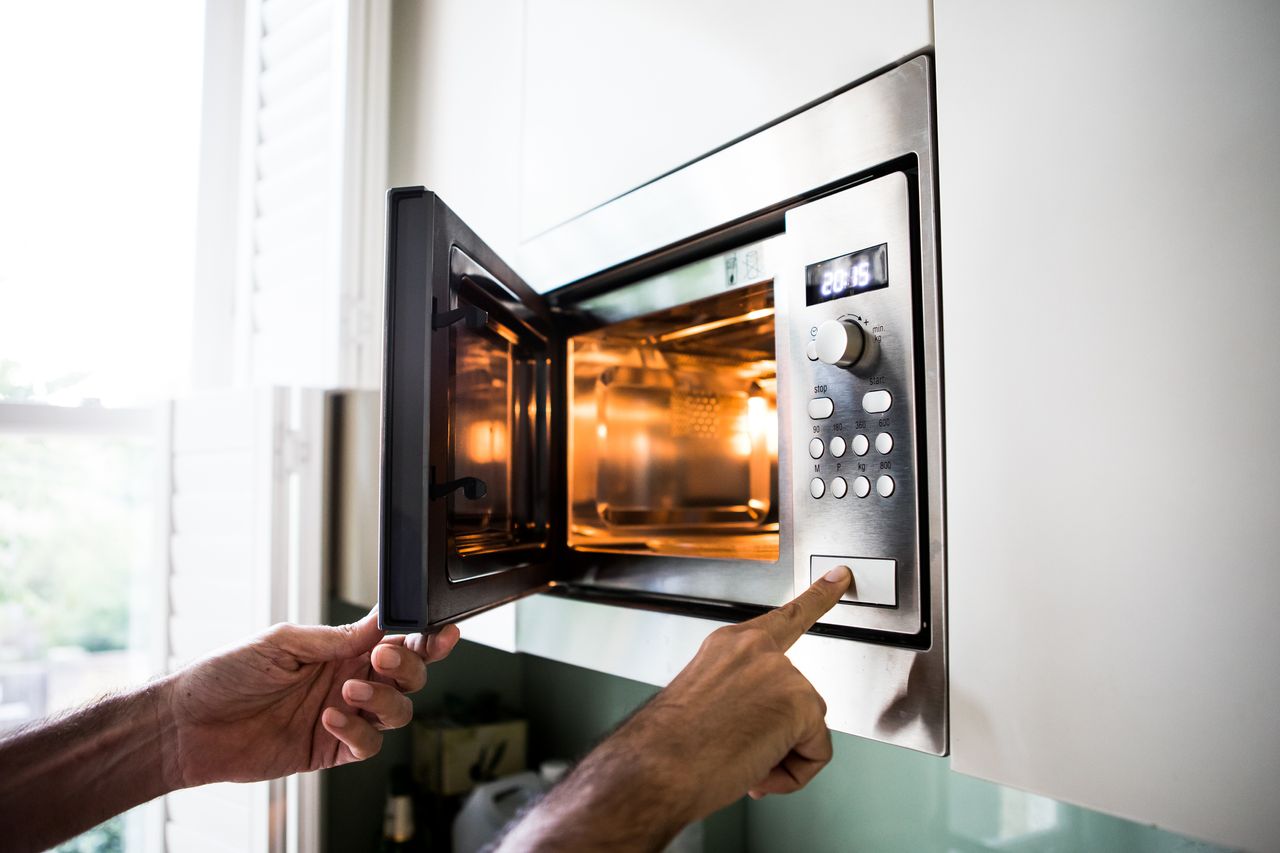 Image of someone opening a microwave. 