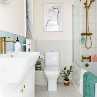 neutral bathroom with pale green tiles and loo