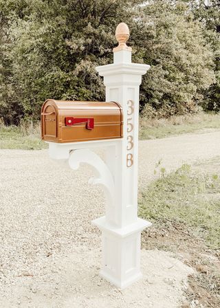 Mailbox landscaping ideas illustrated by a standalone white and metallic mailbox.