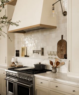 corner of kitchen with creamy white kitchen cabinets and white tiles