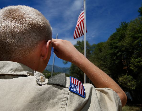 A Boy Scout salutes the American flag.