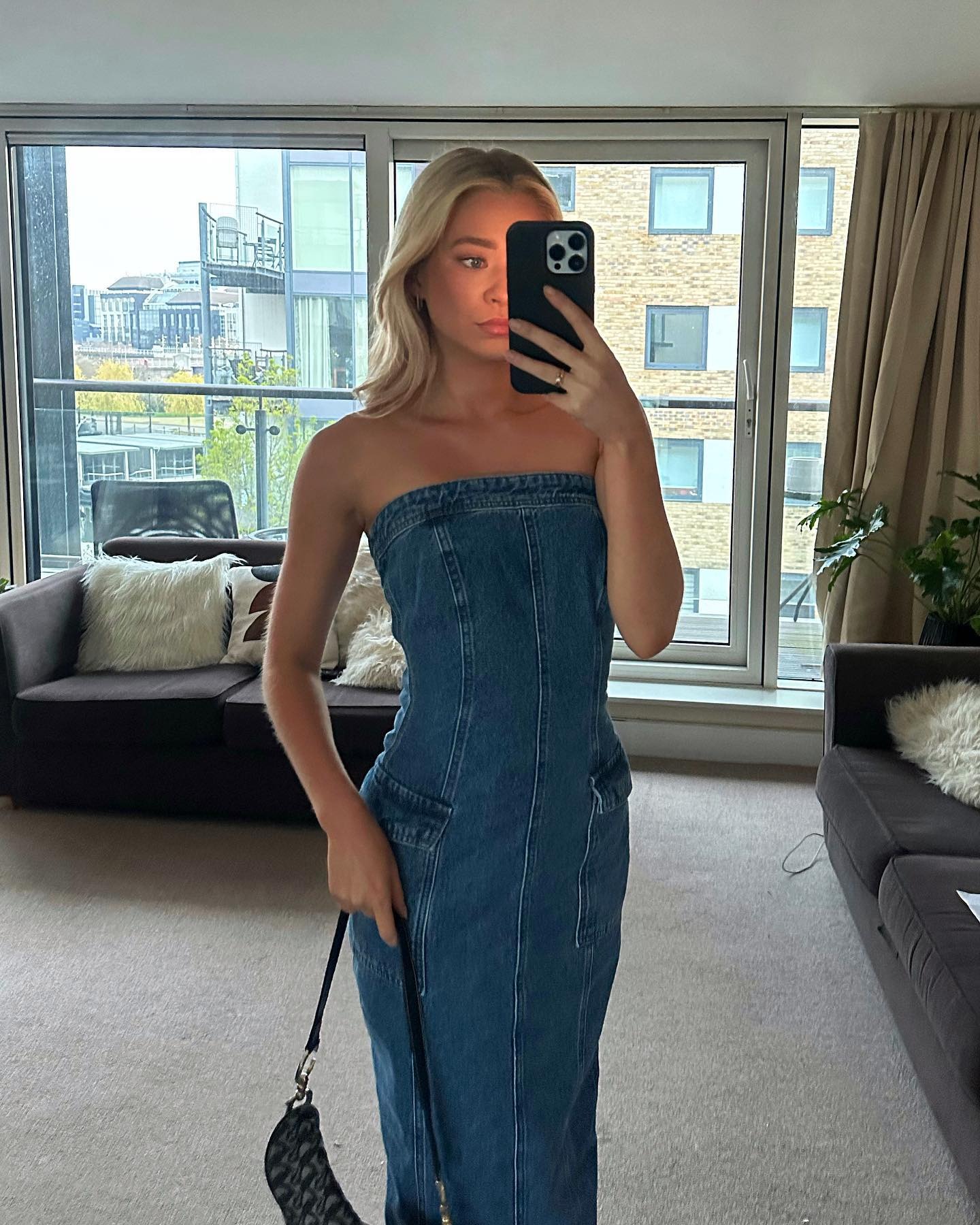 Fashionist Ruby Cox wears denim trend. She paired it with an old-fashioned dior shoulder bag. She is taking a selfie, looking in the mirror in the latest image of her Instagram.