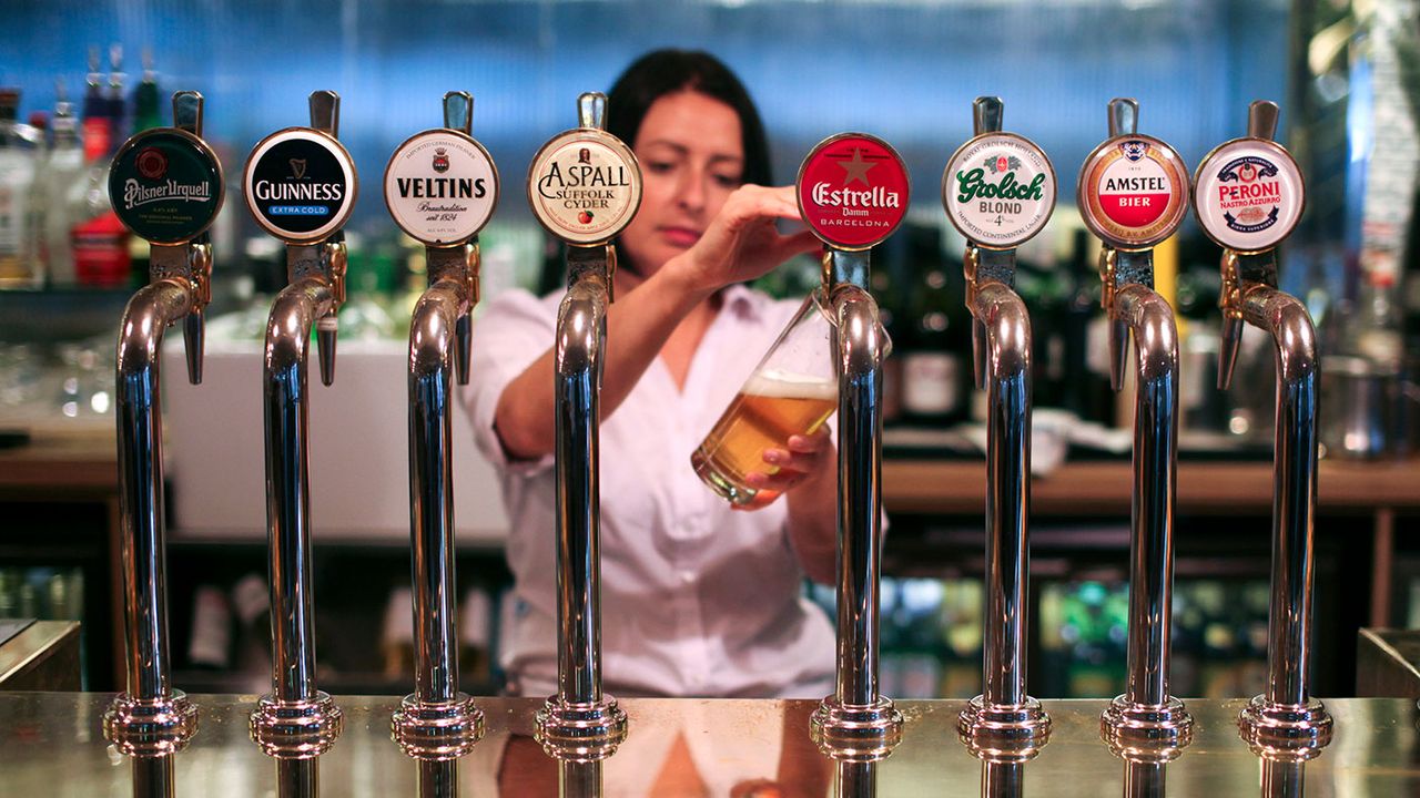 Barmaid pouring beer into a glass