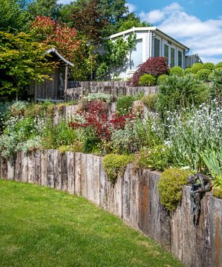 A terraced planting area with rustic wood layeres and rockery style planting.