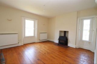 Before pic of dining room with magnolia walls and wooden floorboards