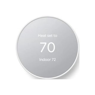 Gray and white round thermostat with text reading heat set to 70 indoor 72