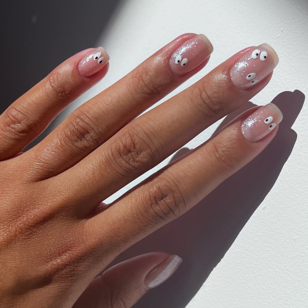 Spooky eye nail art on a sheer shimmer nail polish base