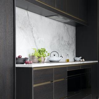 Monochrome kitchen with marble splashback and white whistling kettle