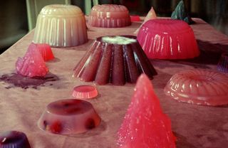 Different shapes and colours of jelly on a table decorated in an artistic way.
