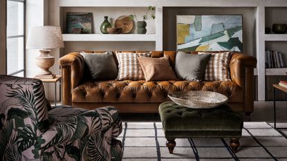 Living room with brown leather Chesterfield sofa and dark green velvet footstool