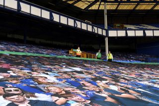 A banner picture of fans covers the seats in the stands before the Merseyside derby on June 21