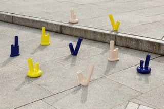 Different sized and coloured bongs on a tiled floor.
