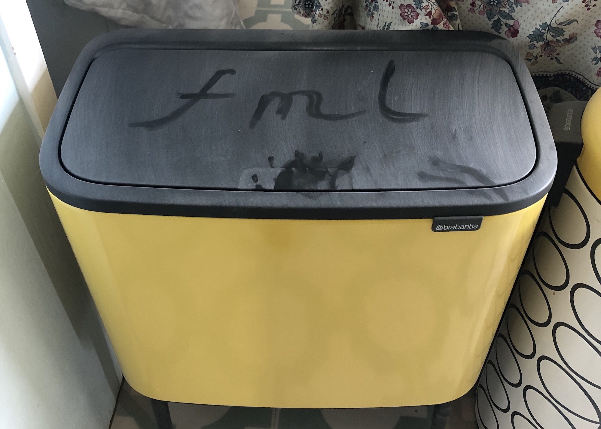 a yellow bin covered in dust