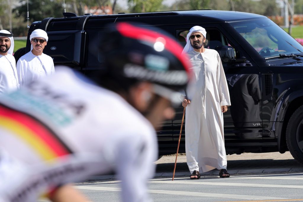 Dubai ruler Sheikh Mohammed bin Rashid Al-Maktoum (R) watches as the pack rides during the fourth stage of the 6th UAE Cycling Tour, in Dubai, on February 22, 2024. (Photo by Giuseppe CACACE / AFP)