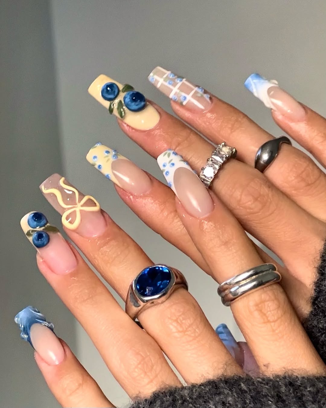 yellow french manicure with blue 3D designs and ribbons
