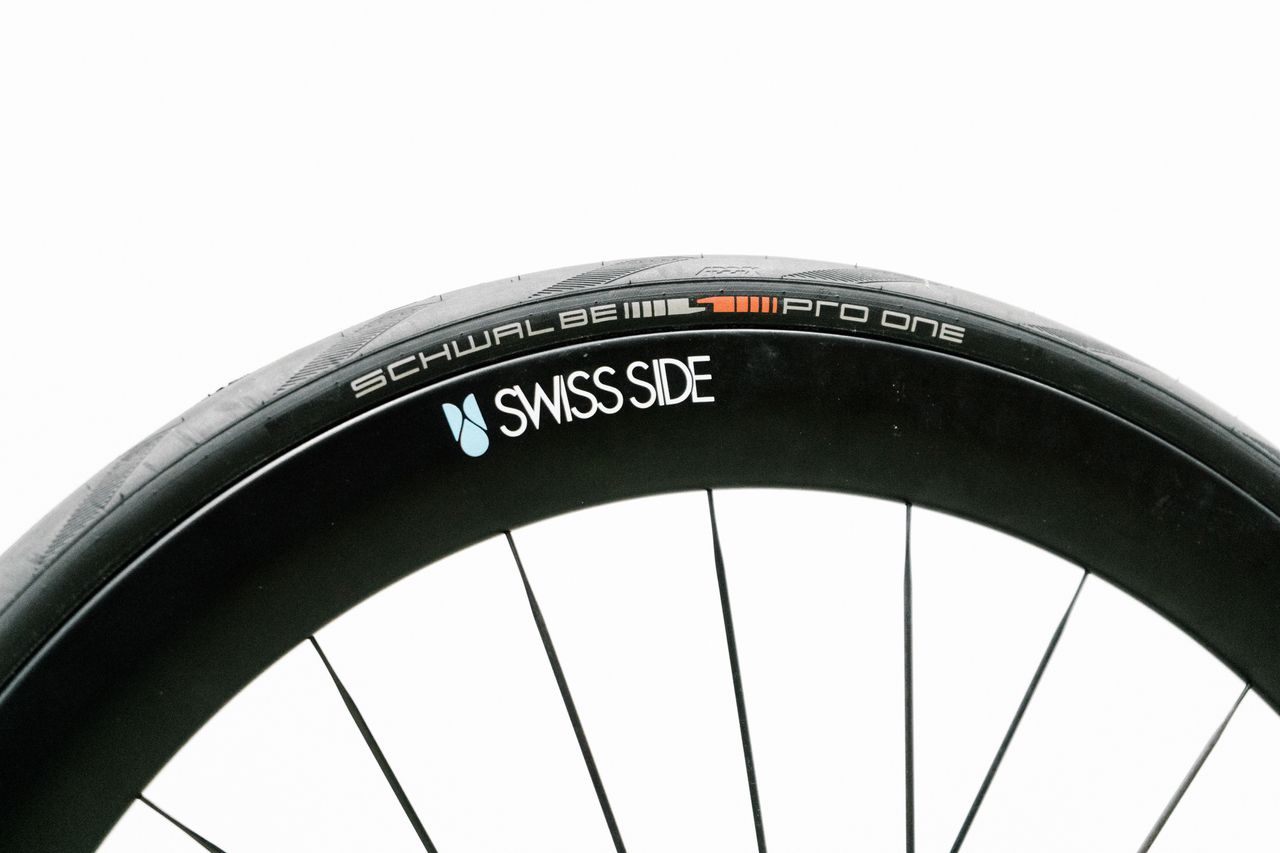An aero road wheel stands against a white wall