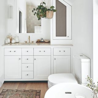 A white bathroom with wall to ceiling built-in storage
