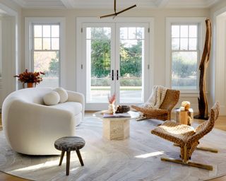 organic style living room with rattan armchairs, travertine coffee table, and curved white sofa