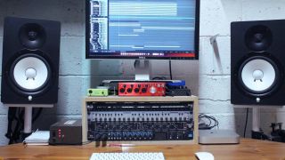 A home studio set up with outboard gear, studio monitors, and audio interface