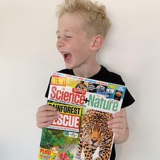 Young boy holding Science + Nature magazine