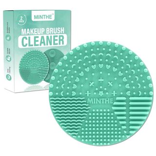 A green circularmakeup brush cleaner pad with packaging