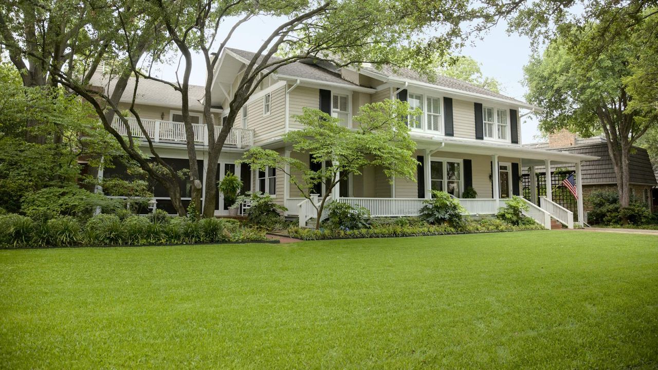 A residential home with large green front lawn