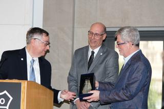 Mark Corl (C), receives the 2018 ATSC  Bernard J. Lechner Outstanding Contributor Award from ATSC President Mark Richer (L) and ATSC Board Chairman Richard Friedel at the ATSC annual meeting. (Photo: James O'Neal)