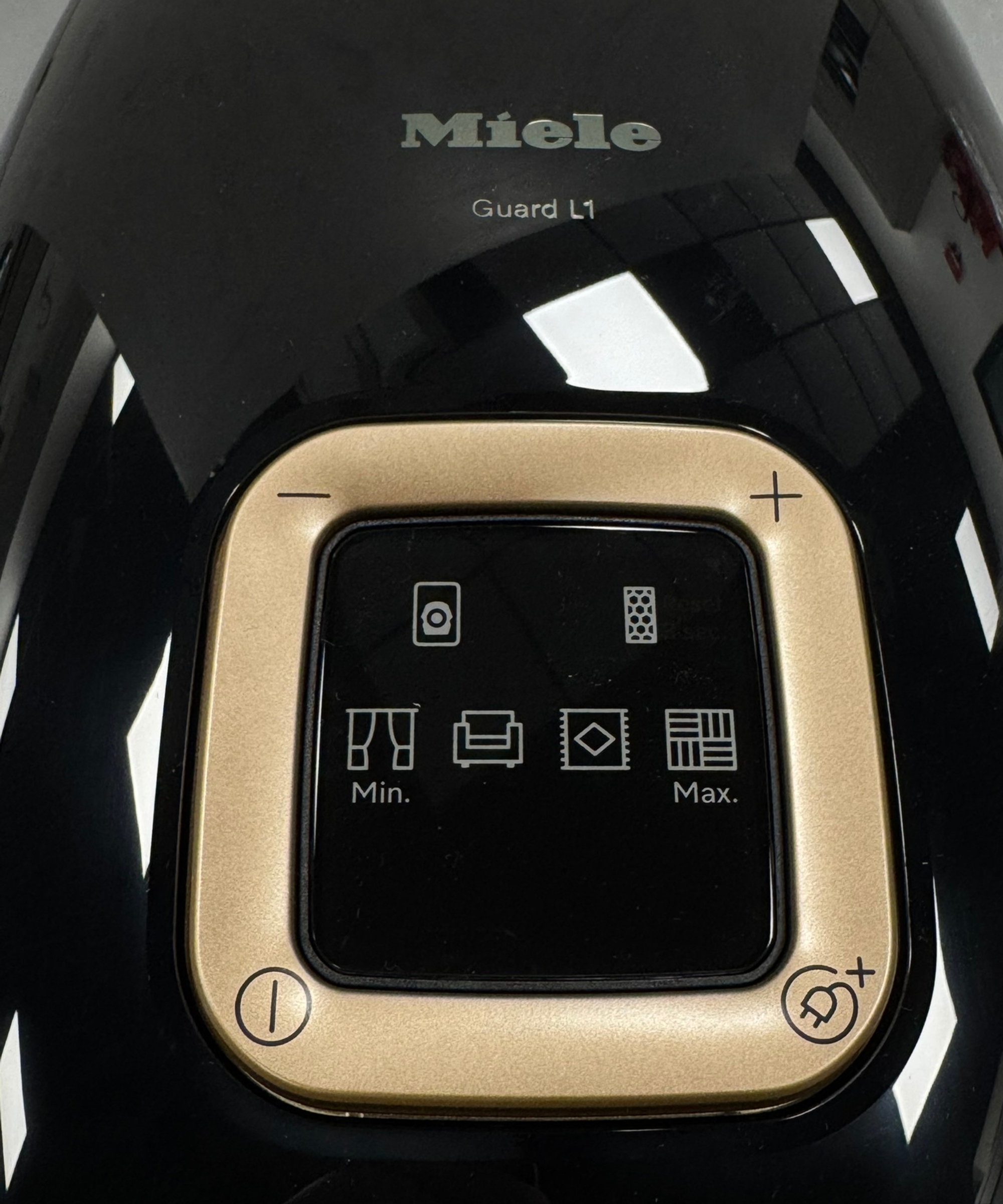 Closeup of the Miele Guard L1 Cat and Dog canister vacuum showing glossy surface, power buttons and suction levels.