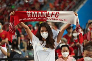 A fan in Thailand brandishes a Manchester United and Liverpool half-and-half scarf