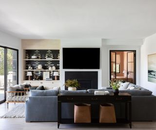 living room with gray sectional sofa and alcove display shelves