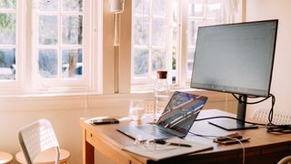A desk with a laptop and one of the best monitors for working from home