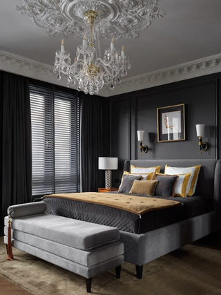 A bedroom with dark gray walls, and ochre bedding