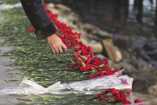 Flowers laid on a sidewalk in mourning.