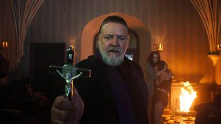 Father Gabriele (Russell Crowe) holds a cross in a scene from "The Pope's Exorcist"