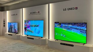 Three 2025 LG QNED TVs (85, 100 and 86 inches, respectively) on display in a posh showroom