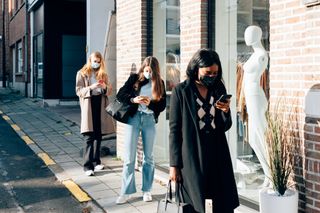 Women queue outside shop as stores which can open until 10 are announced