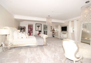 white bedroom with carpet floor and chandeliers