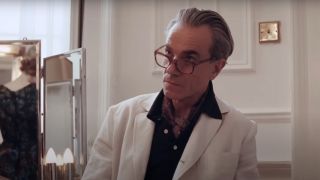 Daniel Day Lewis looks up with an expression of scrutiny in Phantom Thread.