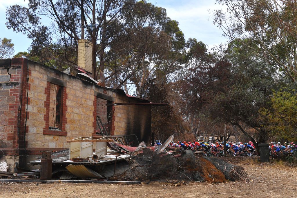 The 2020 Tour Down Under peloton passes the sad scene of a house destroyed by the bushfires during stage 2 between Woodside and Stirling