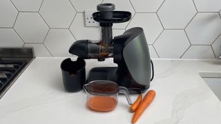 Ninja Cold Press Juicer with carrots and carrots that have been juiced