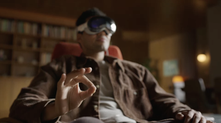 En man som använder ett Apple Vision Pro och gör gester med händerna för att styra virtuella element.