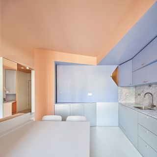 A kitchen with pink and blue walls