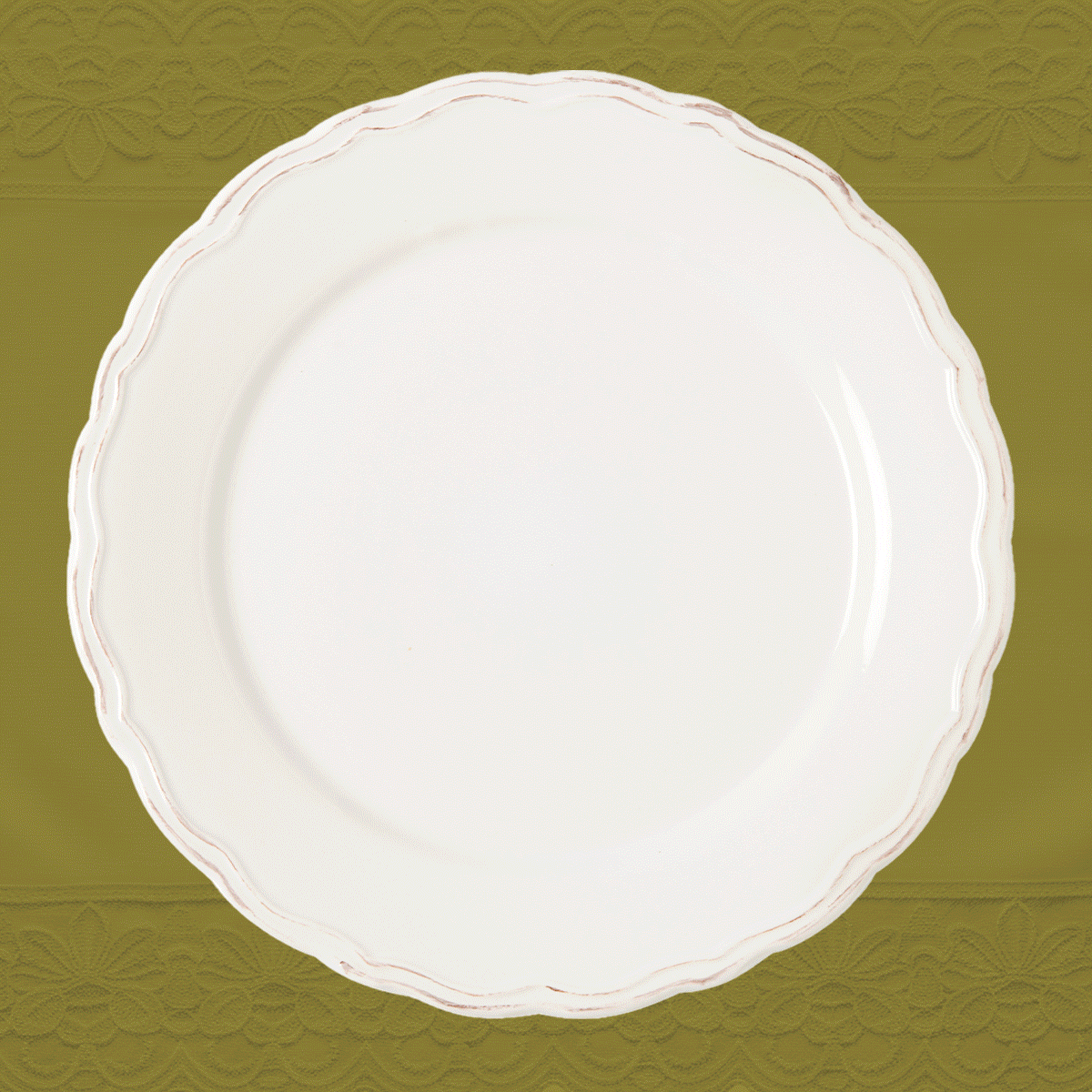 Photo of different luxury fine jewelry colored gemstone pieces on a white plate on olive-colored background.