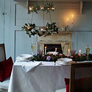 christmas dining room with festive garland and tealight chandelier