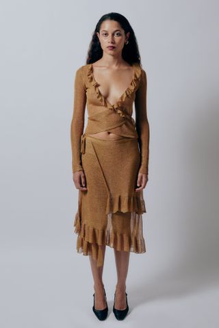 Gauntlett Cheng model wearing brown asymmetrical top and ribbed flared skirt